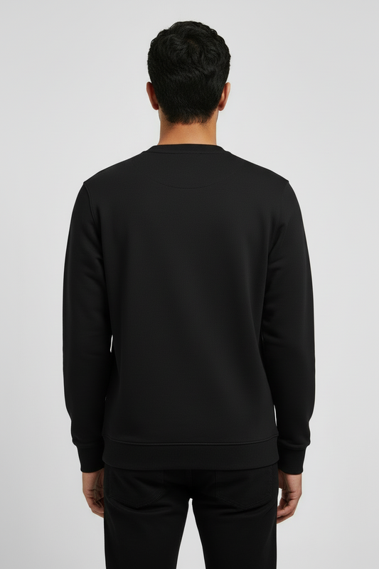 Man wearing a plain black sweatshirt and black jeans, viewed from the back