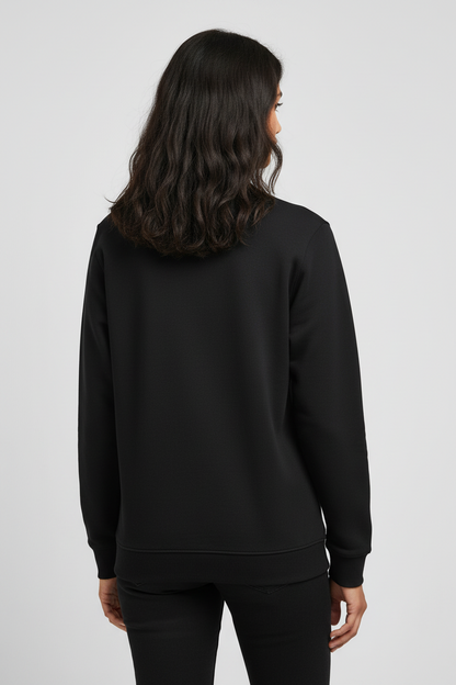 Woman with wavy dark hair wearing a plain black sweatshirt and black pants, back view