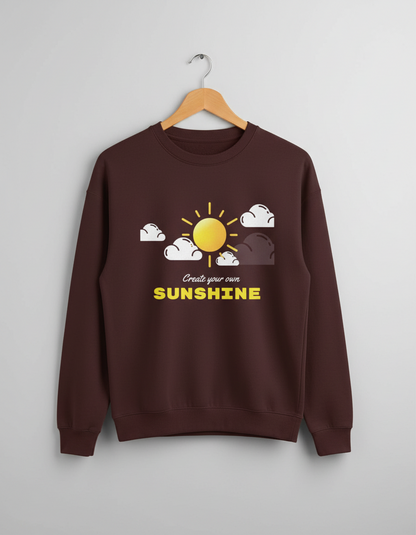 Brown sweatshirt with sunshine and clouds graphic and text 'Create your own SUNSHINE' on front