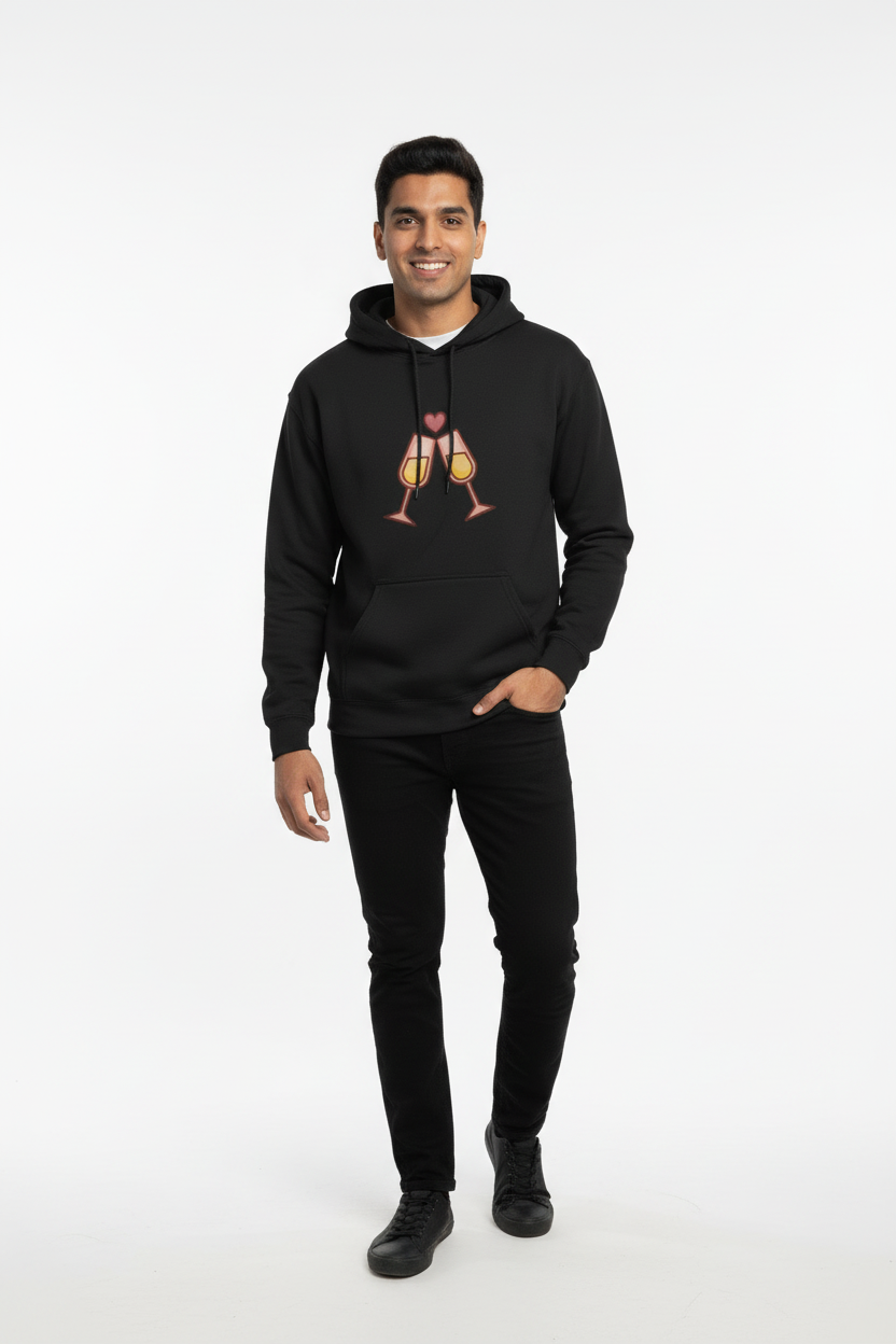 Smiling man wearing black hoodie with clinking champagne glasses and heart design, black pants and shoes