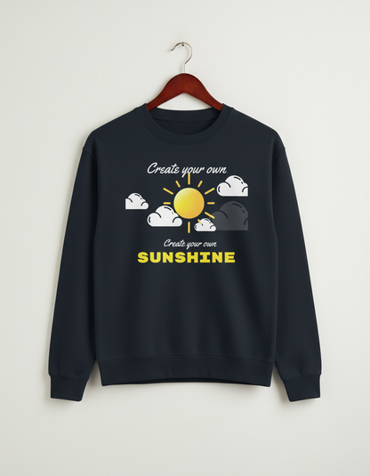 Black crewneck sweatshirt with sun and clouds graphic and text 'Create your own SUNSHINE' hanging on wooden hanger